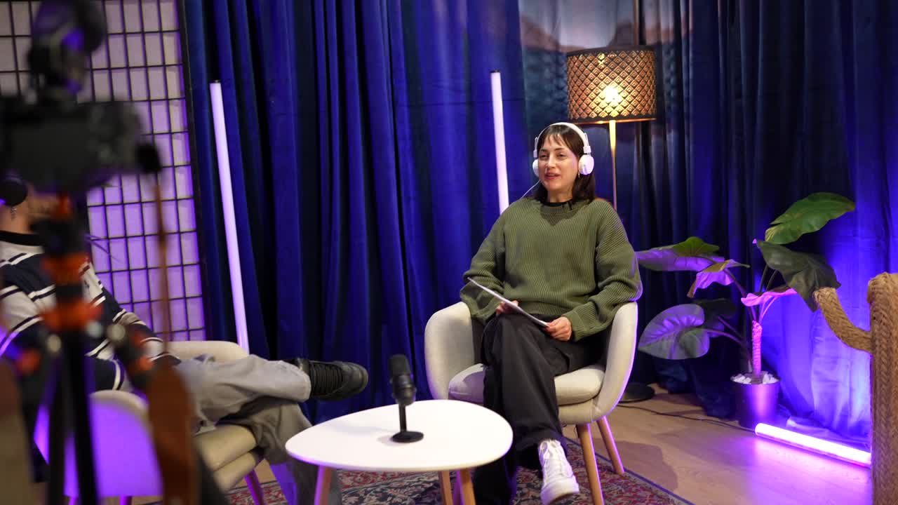 Muž a žena nahrávají podcastový rozhovor v moderním studiu