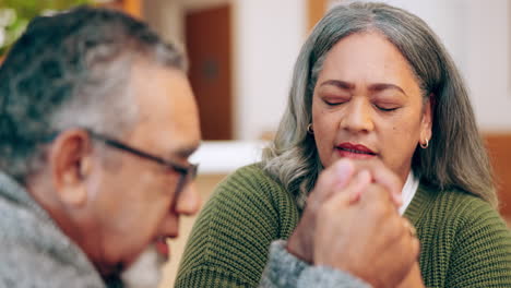 senior couple praying in home for faith