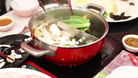 preparing hotpot with vegetables and mushrooms