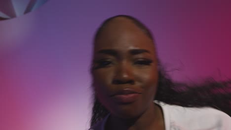 studio shot of young woman dancer dancing against blue and pink lit background 14