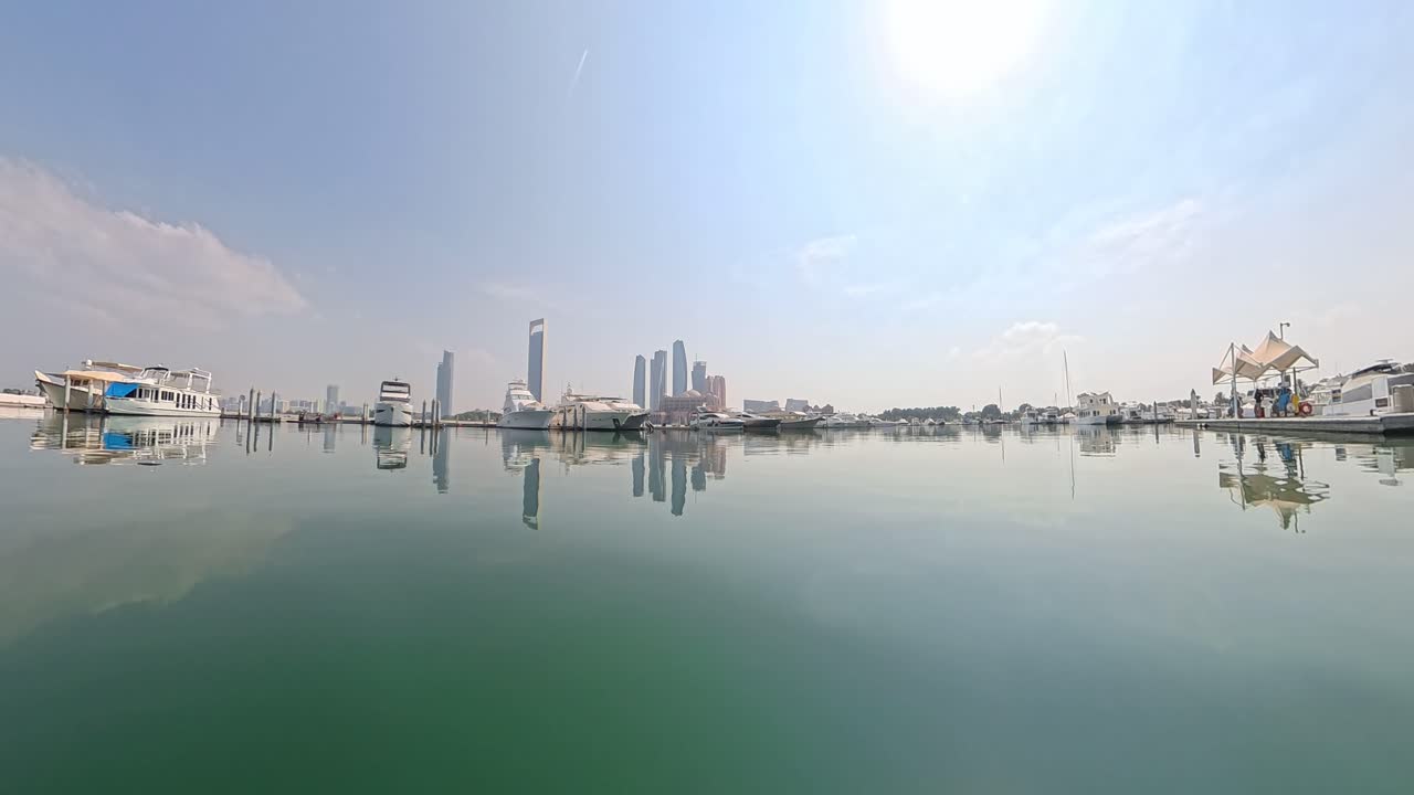 Abu Dhabi's skyline reflecting on calm waters from the Emirates Palace Marina