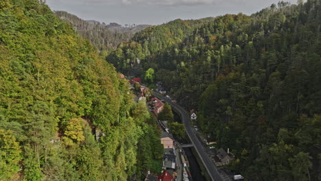 hrensko czechia aerial v7 birds eye view drone flyover along kamenice river capturing small village town hidden in the valley surrounded by lush green forests - shot with mavic 3 cine - november 2022