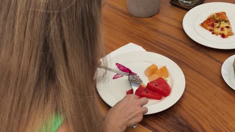mujer disfrutando de un desayuno de ensalada de frutas