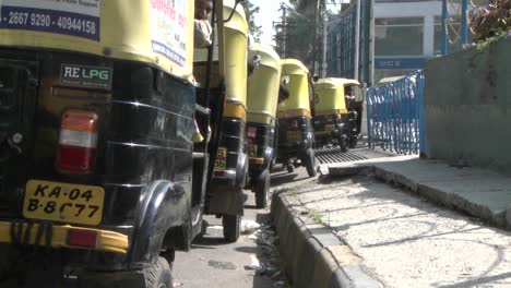 taxi drivers parked on the side of the street wait for customers