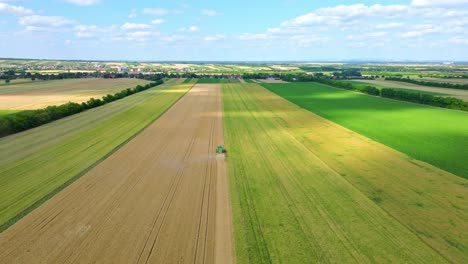 combine harvesting wheat in summer - drone shot