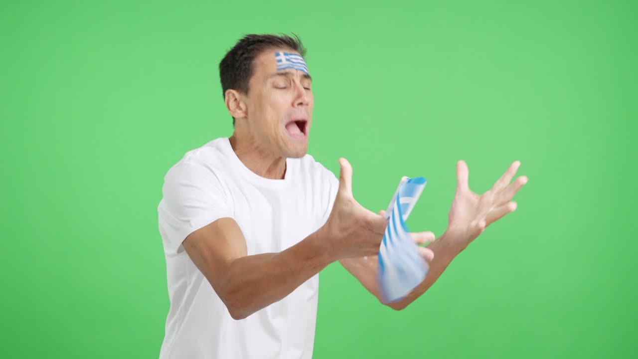 Nervous man cheering for Greece during a match looking away