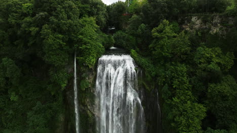 marmore falls surrounded with lush vegetation in umbria, italy - aerial drone shot