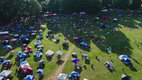 tents and people crowding on meadows of piedmont park during jazz festival outdoor concert in atlanta, georgia, usa. aerial shot