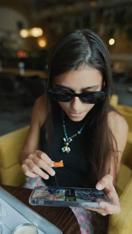 teenage girl using phone in a cafe