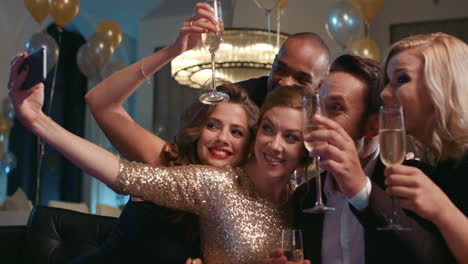 Smiling-group-of-friends-celebrate-evening-event-with-selfie-at-party