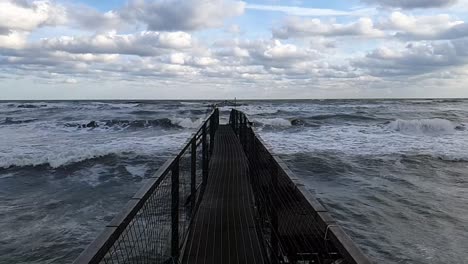 dark metal pier in leading into the ocean