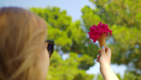 Woman-with-red-flowers-bouquet-in-waffle-cone-outdoor