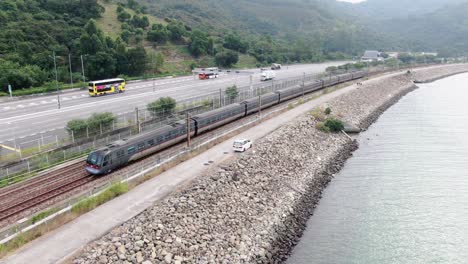 hong kong mtr train crossing a rural part of hong kong bay, aerial view