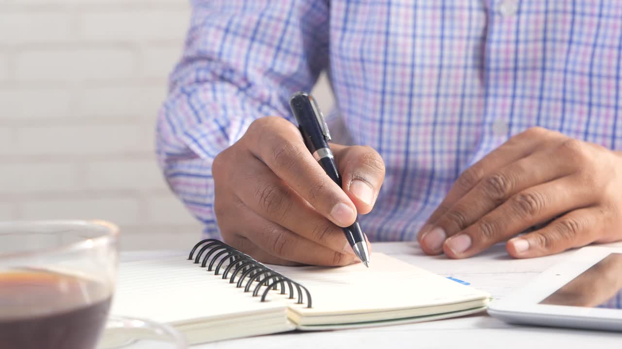 Person Writing in a Notebook