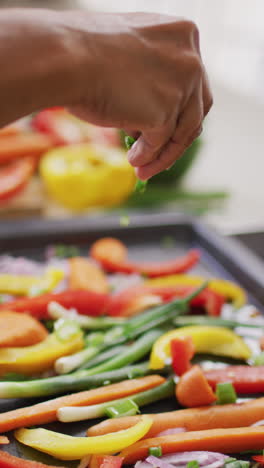 Vertical video of senior biracial woman cooking in kitchen