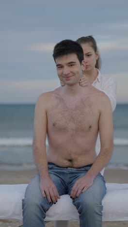 man getting a shoulder massage on the beach