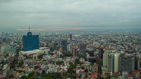 Vista-Aérea-En-Movimiento-De-Lapso-De-Tiempo-De-Nubes-Nubladas-Que-Se-Mueven-Sobre-La-Ciudad,-Revelando-Un-Colorido-Cielo-De-Amanecer,-En-México,-América---Reversa,-Hiperlapso,-Disparo-De-Drones