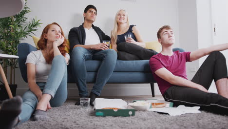 Gruppe-Von-College-Studenten-Im-Gemeinsamen-Haus,-Die-Fernsehen-Und-Pizza-Essen