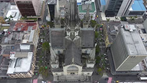 Inclinando-Hacia-Abajo-Con-El-Dron-Desde-Lo-Alto-De-Una-Catedral-En-Manizales,-Colombia-A-Una-Plaza