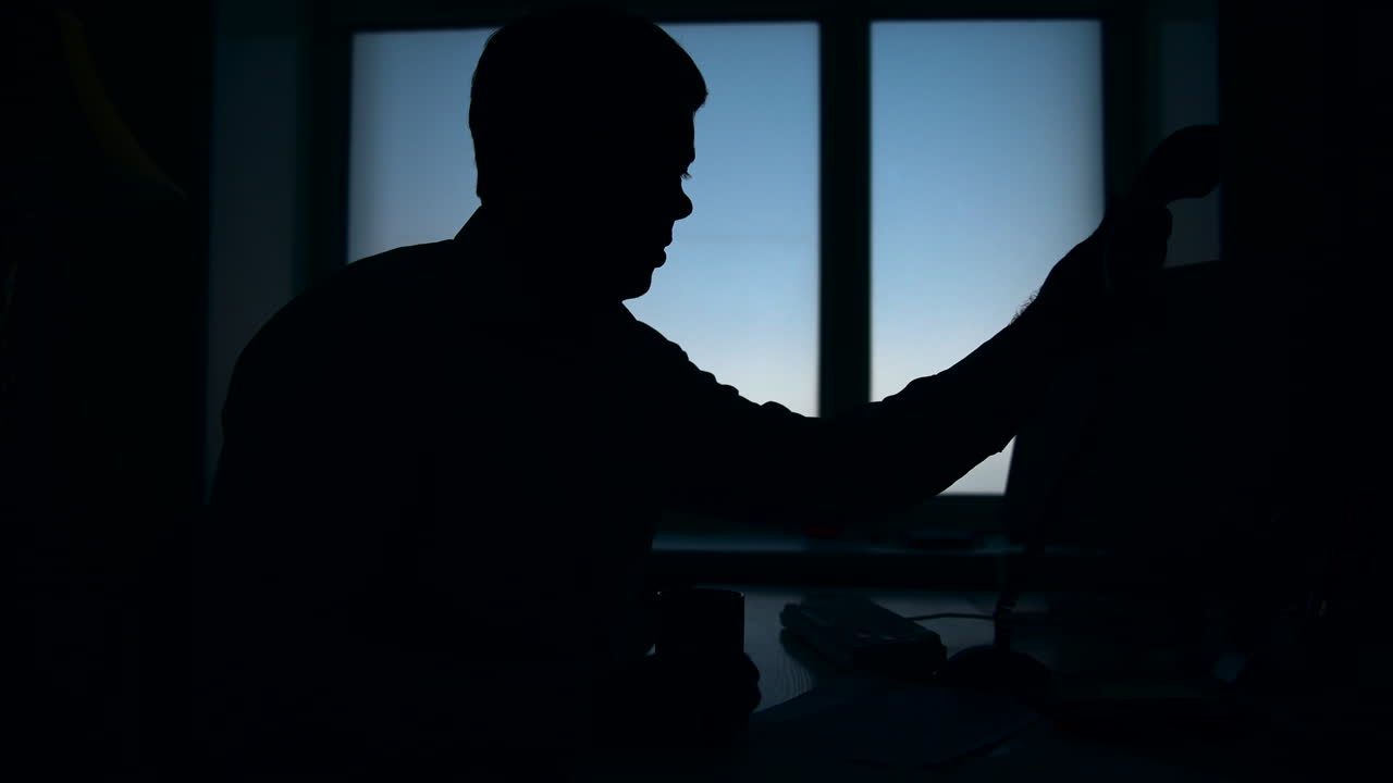 Silhouette Man On Phone In Dim Office, Investigator Exchanging Confidential Details, Tense Posture By Window, . Media