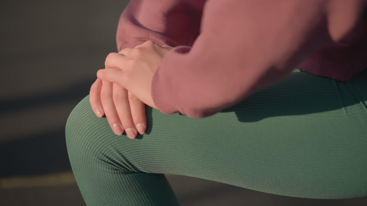 primer plano de una persona joven que realiza ejercicios de acondicionamiento físico, arrodillada hacia adelante con las manos apoyadas en las rodillas, sombras proyectadas en el suelo que crean un enfoque dinámico en el estilo de vida saludable y el movimiento de entrenamiento