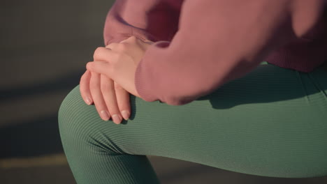 close up of young person engaging in fitness exercise, kneeling forward with hands resting on knee, shadows cast on ground creating dynamic focus on healthy lifestyle and workout movement