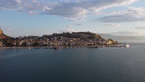 Vista-Aérea-De-La-Pintoresca-Ciudad-Mediterránea-De-Nauplio-En-La-Región-Del-Peloponeso-De-Grecia,-Durante-Una-Tarde-Nublada-Con-Yates-En-El-Puerto-|-4k