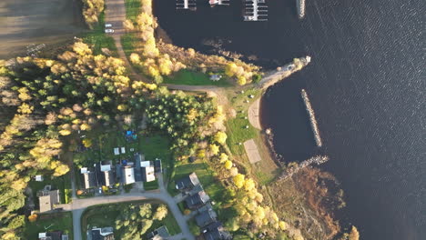 residential village with autumn foliage near marina by the lakefront in sweden