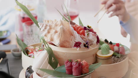 Person-Picking-And-Eating-Salmon-Sashimi-Sushi-With-Chopsticks-In-A-Japanese-Restaurant