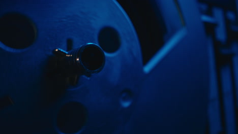 a vintage tape recorder spinning spools in a blue light