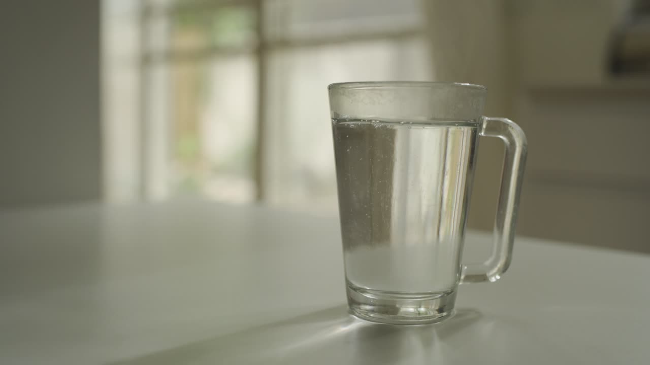 verter agua caliente de un hervidor a una taza de vidrio en casa