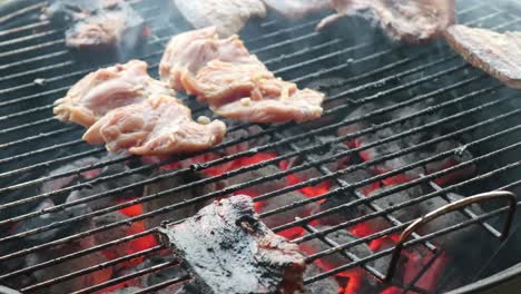 placing chicken thigh fillets for grilling on a charcoal bbq