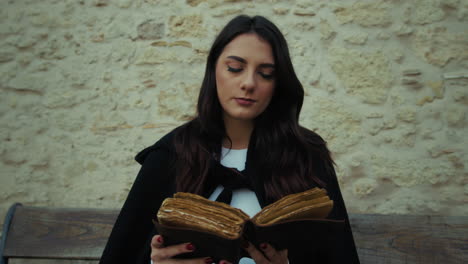 woman reads an ancient book sitting in the medieval city