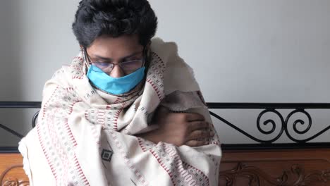 person wrapped in blanket with mask and glasses