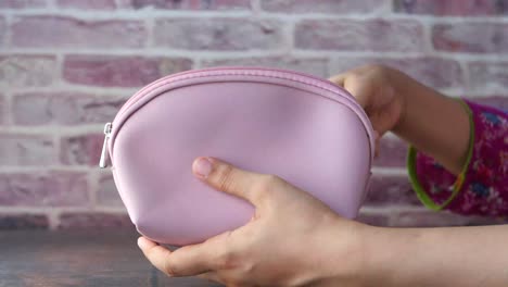 woman putting a coin into a pink purse