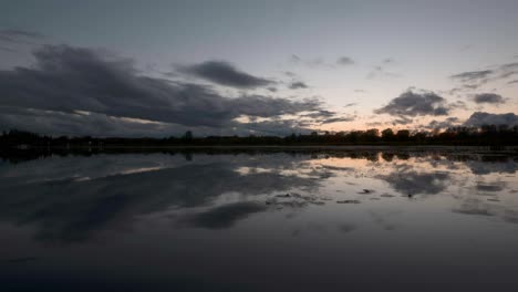 Timelapse-of-a-lake-at-dusk-with-rippling-water-and-a-beautiful-sunset