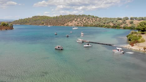 Drone-Sobre-Embarcaciones-De-Recreo-Que-Comienzan-A-Navegar-En-Aguas-Azules,-Grecia,-Verano-Soleado