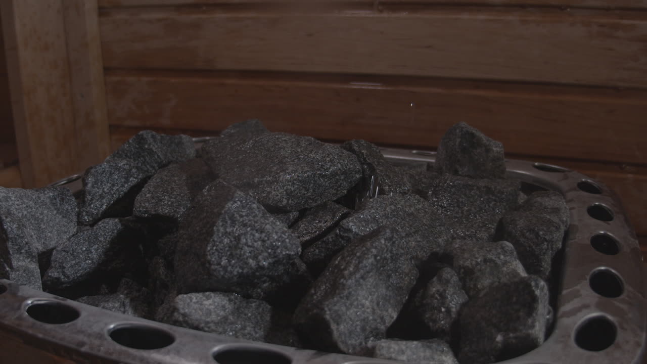 verter agua sobre las piedras en la sauna para proporcionar calor y vapor