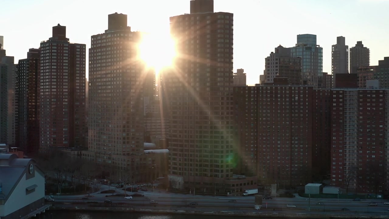 Vista do horizonte da cidade de Nova York ao pôr do sol com edifícios e rio