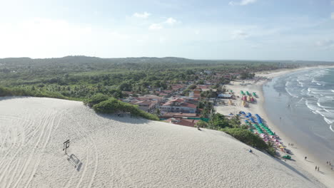 aerial - parasols and people on genipabu beach, brazil, forward truck right reveal