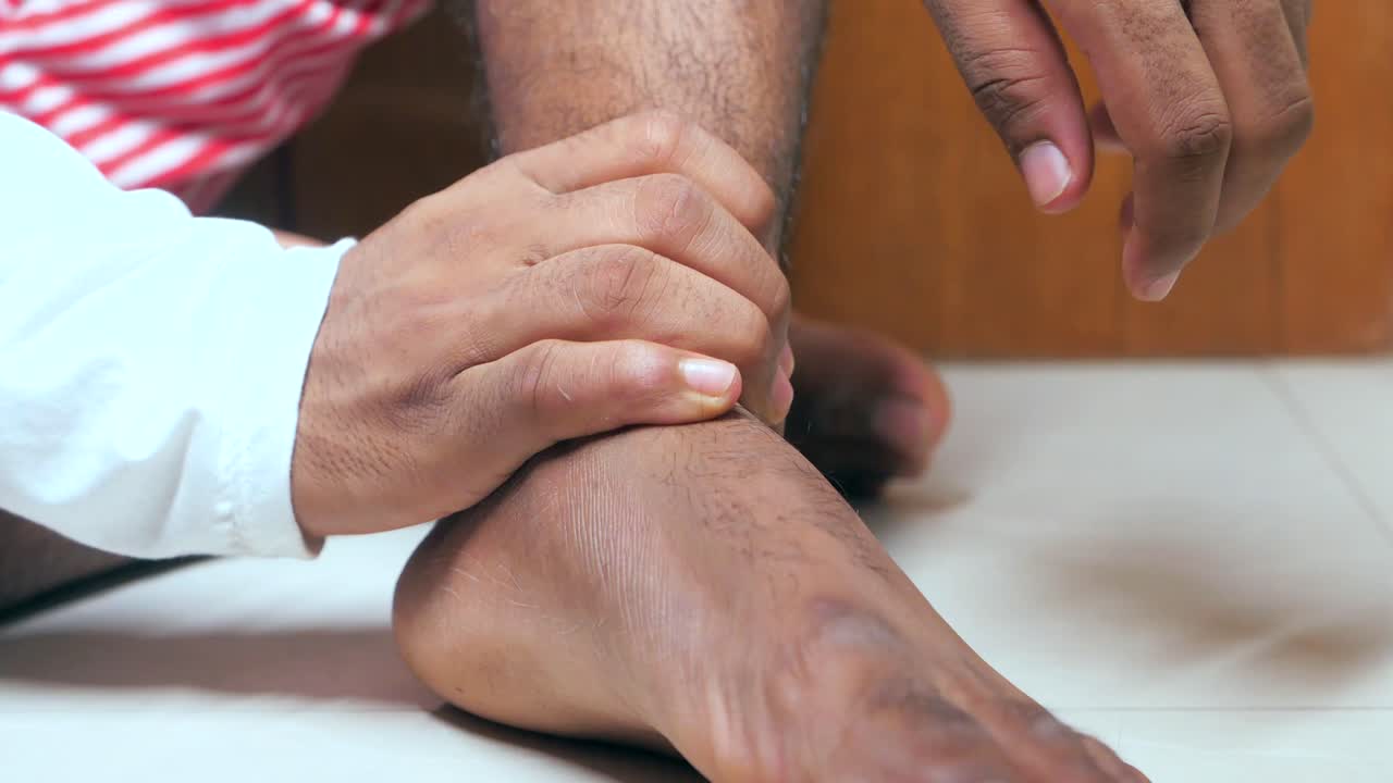 Uomo che si massaggia la caviglia