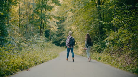 amigos despreocupados caminando entre los árboles en el bosque