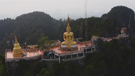 golden statue of meditating buddha in tiger cave temple in thailand