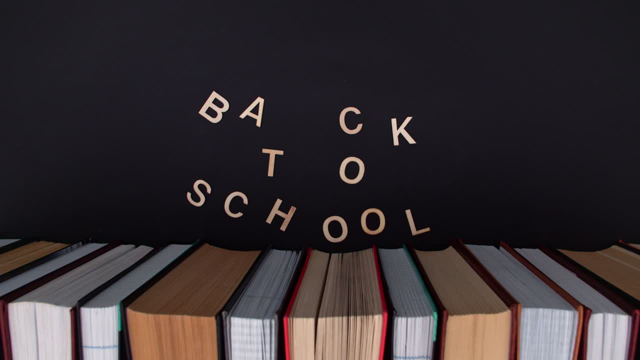 School books on the desk with chalkboard in the background