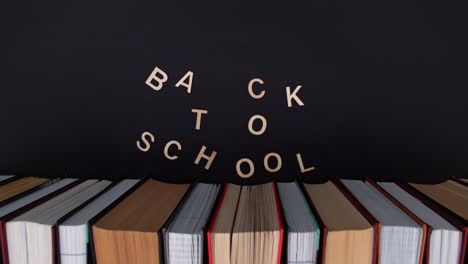 school books on the desk with chalkboard in the background