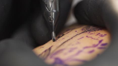 Macro shot of tattooing process in a professional tattoo studio. Shot in slow motion 120fps