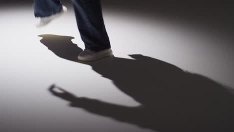 disparo de estudio de cerca que muestra los pies de una mujer bailando con iluminación de baja clave contra un fondo gris 6