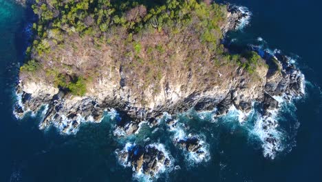 el vuelo estacionario de las olas costeras rompiendo hacia adelante revela una gran playa blanca con fondo de montaña