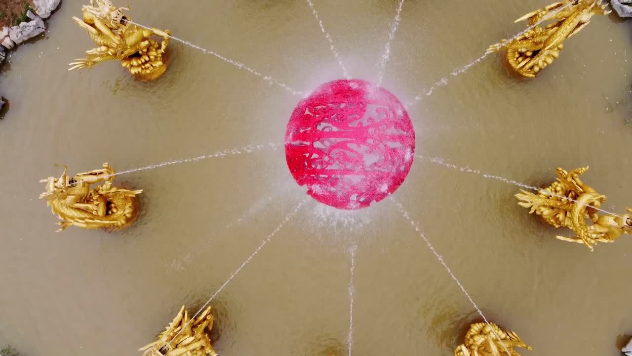 Cinematic drone flying bird's eye view over golden chinese dragon water fountain