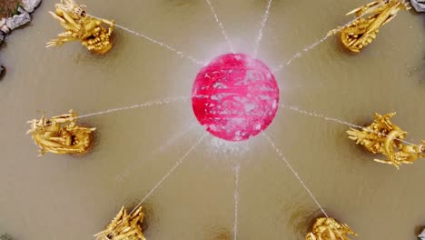 Cinematic drone flying bird&#039;s eye view over golden chinese dragon water fountain
